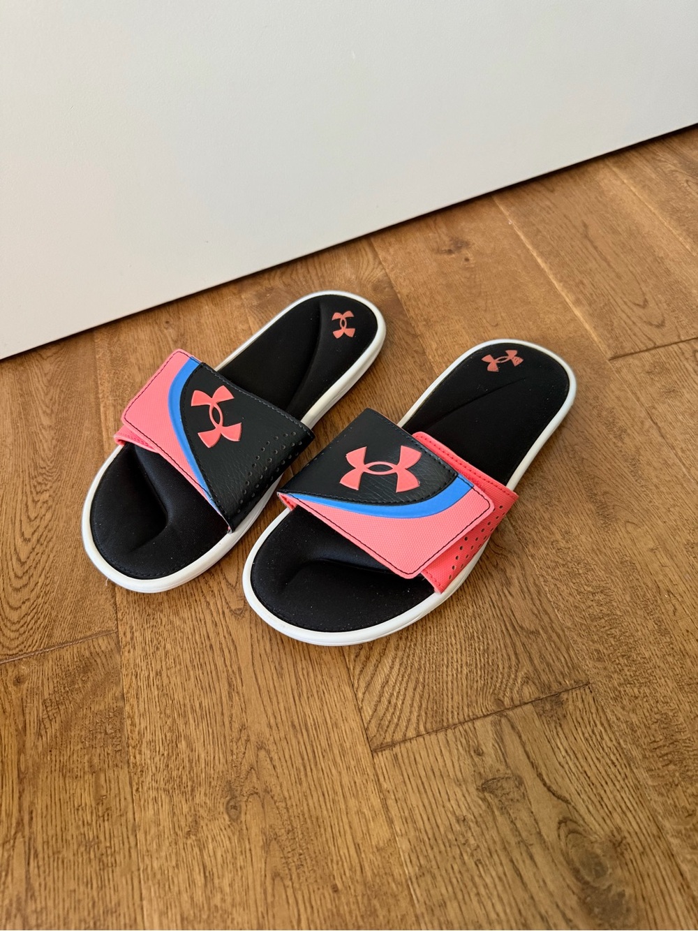 Under Armour Ignite VI coral and black slides with pink and blue accents sandals